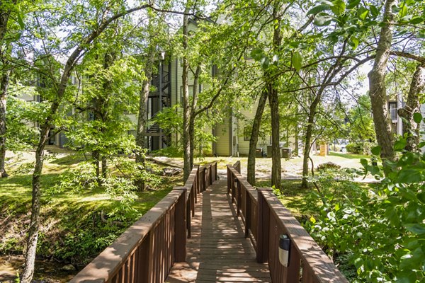 Scenic walking trail at Ashton Brook Apartments surrounded by lush greenery, providing a serene outdoor experience for residents