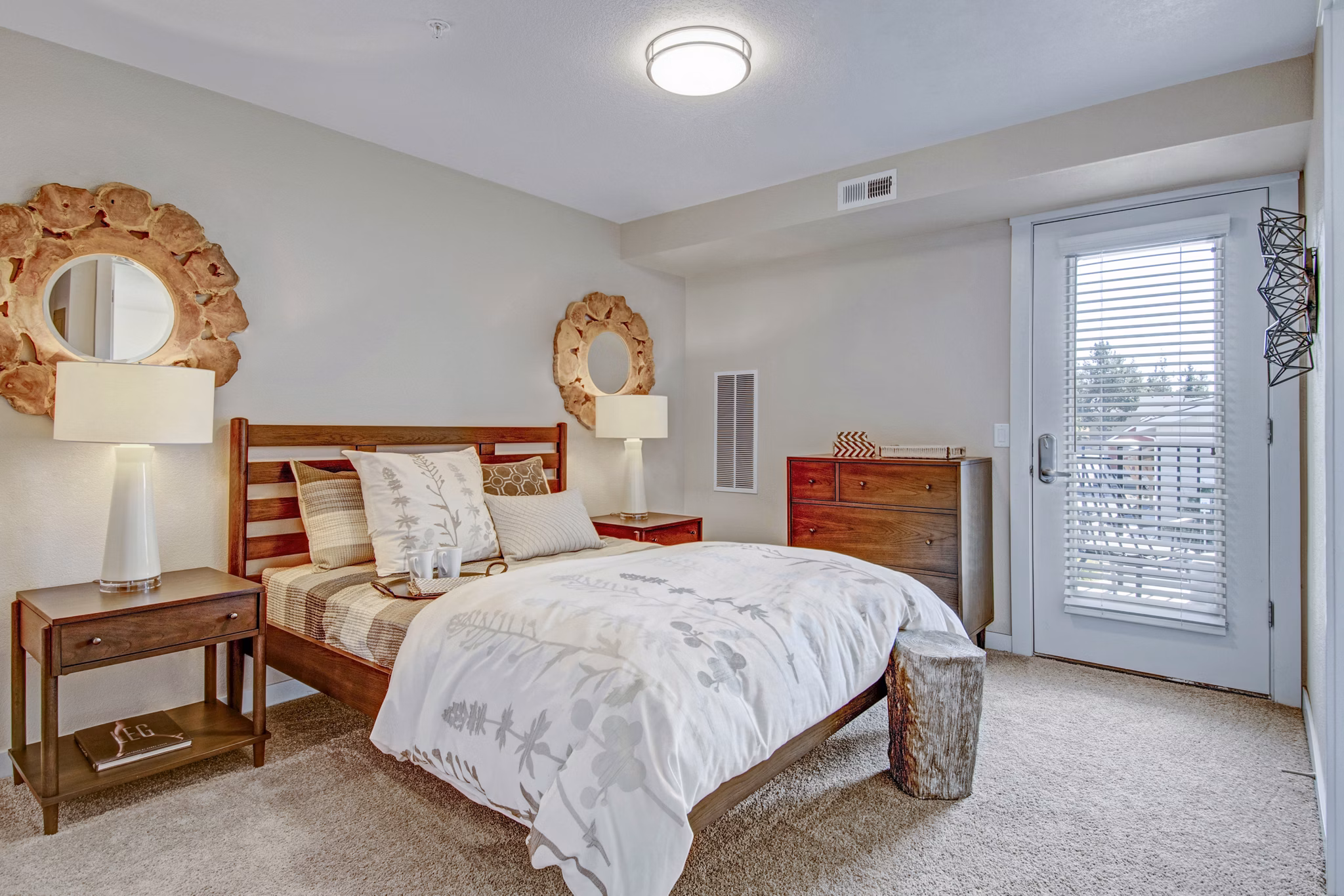 Modern bedroom with cozy dÃ©cor at Seasons at Farmington Reserve Apartments, featuring a stylish bed and large window for natural light