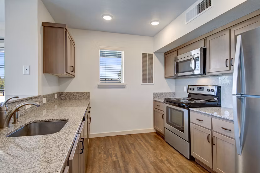 Open-concept kitchen with modern appliances at Seasons at Farmington Reserve Apartments