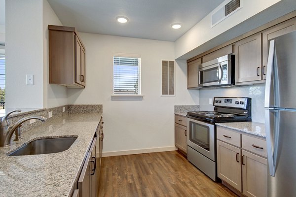 Open-concept kitchen with modern appliances at Seasons at Farmington Reserve Apartments