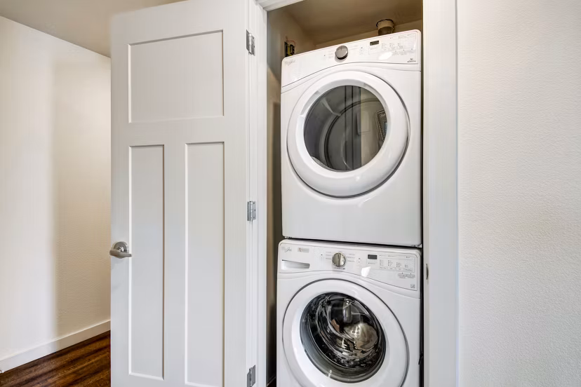 Laundry room with modern appliances at Seasons at Farmington Reserve Apartments