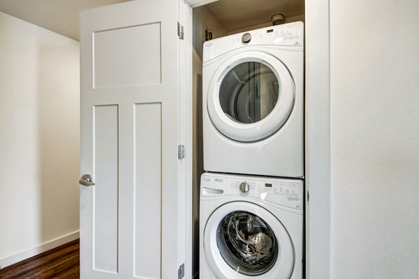 Laundry room with modern appliances at Seasons at Farmington Reserve Apartments