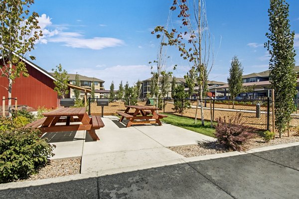 Outdoor grilling patio with modern furniture at Seasons at Farmington Reserve Apartments, ideal for gatherings and relaxation