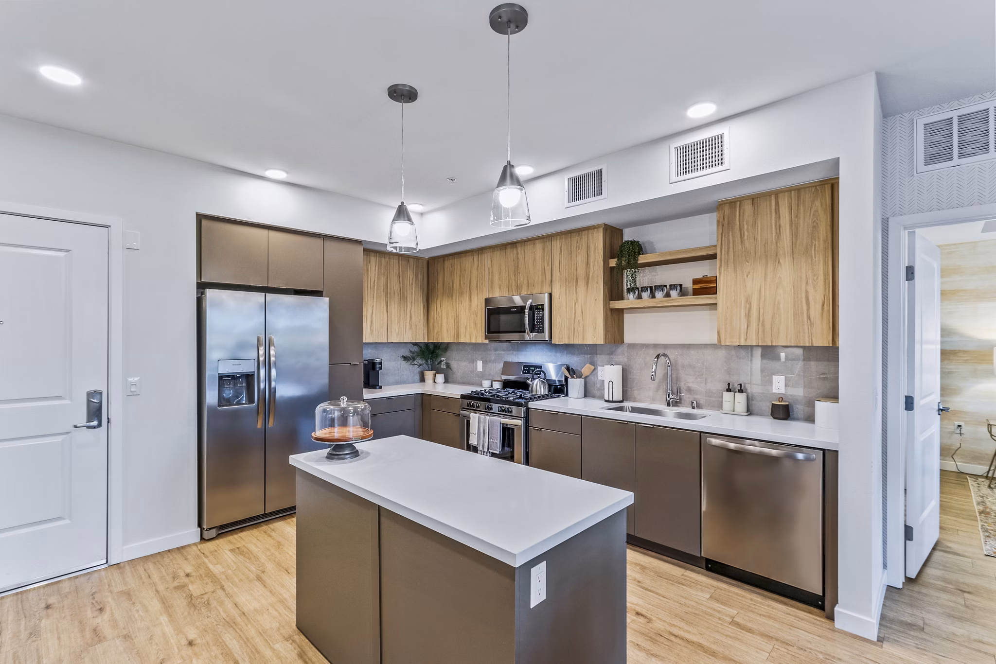 Modern kitchen with stainless steel appliances and granite countertops at Jefferson La Mesa Apartments