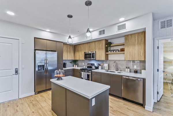 Modern kitchen with stainless steel appliances and granite countertops at Jefferson La Mesa Apartments