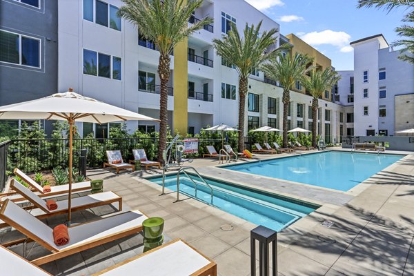 Sparkling outdoor pool at Jefferson La Mesa Apartments with luxurious lounge chairs and landscaped surroundings