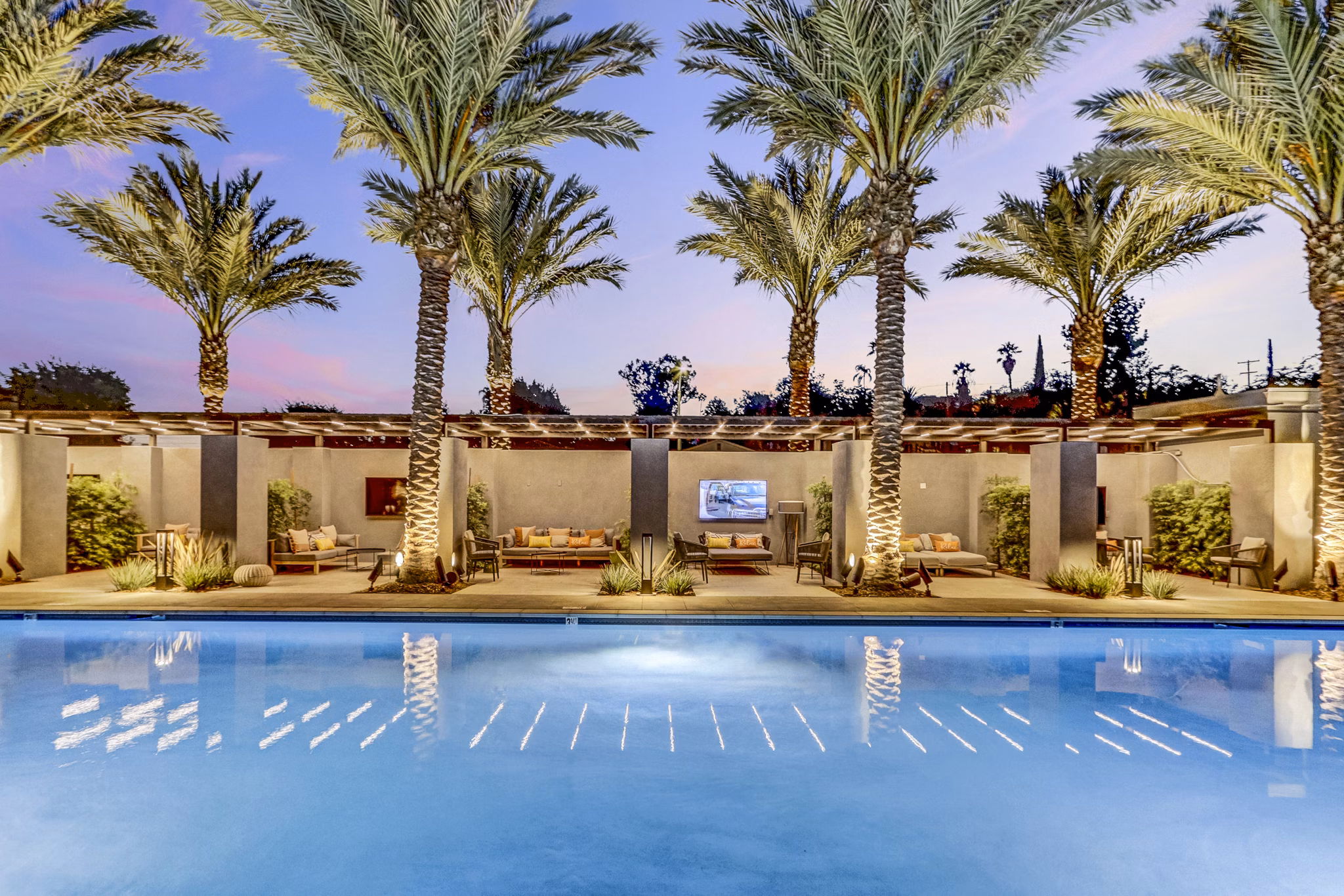 Modern outdoor pool with lounge chairs at Jefferson La Mesa Apartments