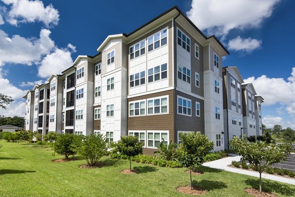 Luxury apartments with a landscaped lawn and mature trees in front