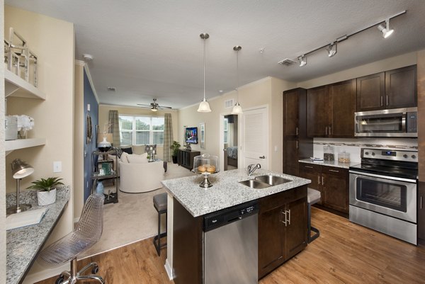 Sleek kitchen with stainless steel appliances and granite countertops in Integra Lakes Apartments