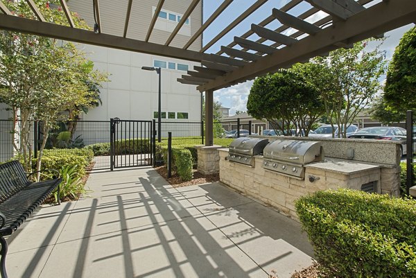 Outdoor patio featuring barbecue grills and a pergola at luxury apartments