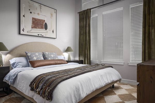 Cozy bedroom with modern design and ample natural light at The Ludlow Apartments