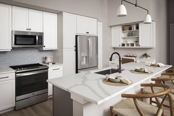 Modern kitchen featuring stainless steel appliances and granite countertops at The Ludlow Apartments