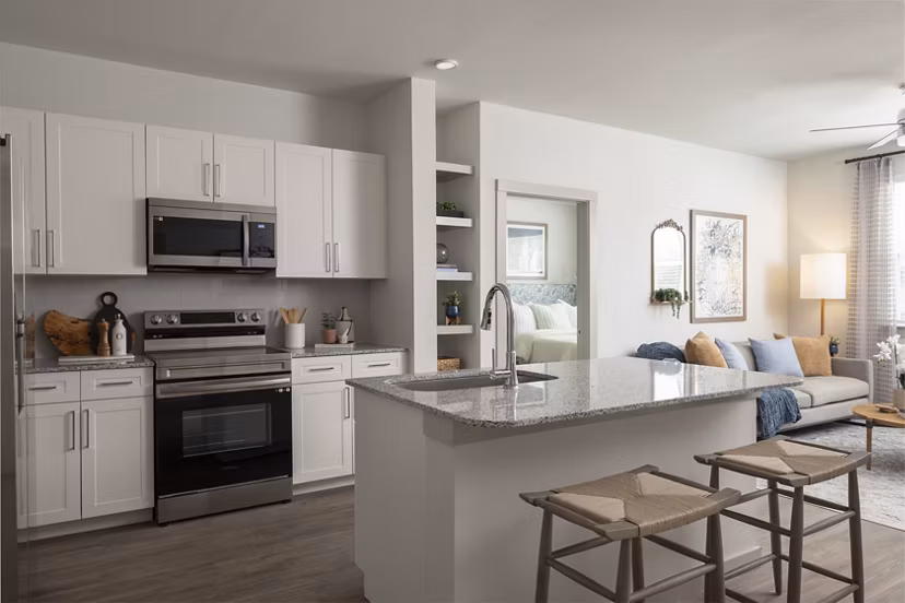 Modern kitchen with stainless steel appliances and sleek countertops at Prose North West Apartments
