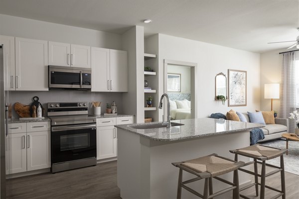 Modern kitchen with stainless steel appliances and sleek countertops at Prose North West Apartments