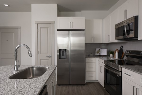 Kitchen featuring modern appliances and granite countertops in Prose North West Apartments luxury community