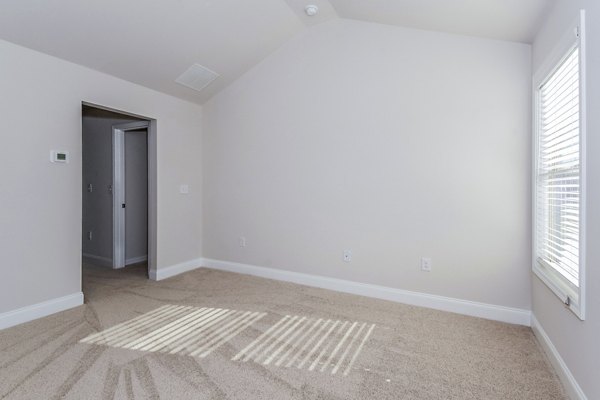 Tranquil Gardens Apartments: Cozy bedroom featuring plush bedding and natural light