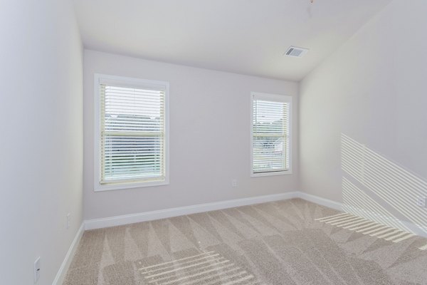 Tranquil Gardens Apartments: Cozy bedroom featuring modern decor and ample natural light luxury apartments