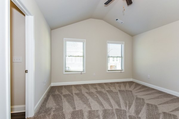 Cozy bedroom with plush bedding and natural light in Tranquil Gardens Apartments