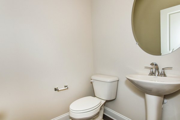 Bathroom featuring sleek fixtures and natural stone tiles in Tranquil Gardens Homes luxury apartment