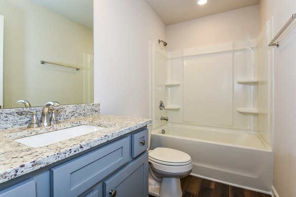 Modern bathroom featuring marble countertops and open glass shower in Tranquil Gardens Homes