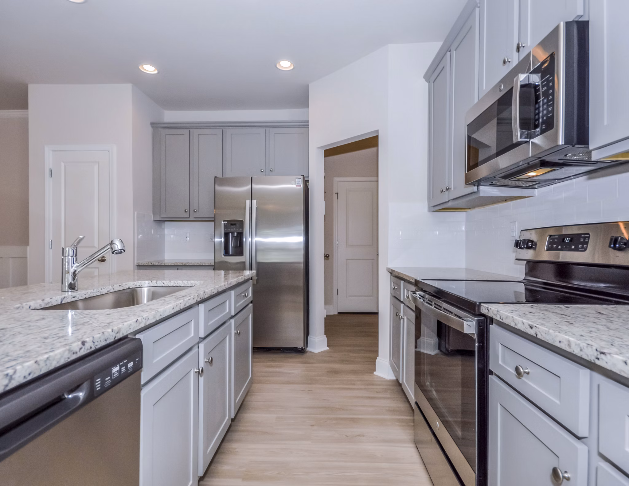Modern kitchen featuring sleek countertops and stainless steel appliances in Tranquil Gardens Apartments