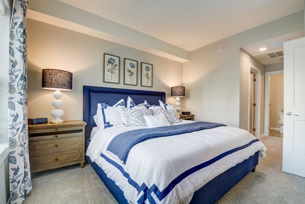 Modern bedroom with stylish decor at Outlook Hamilton Apartments, featuring plush bedding and spacious design for luxury living