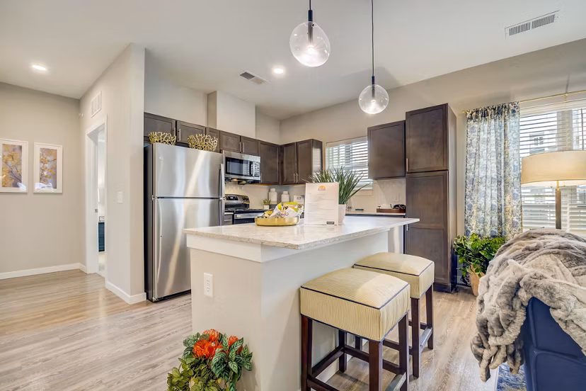 Modern kitchen with granite countertops and stainless steel appliances in Outlook Hamilton Apartments