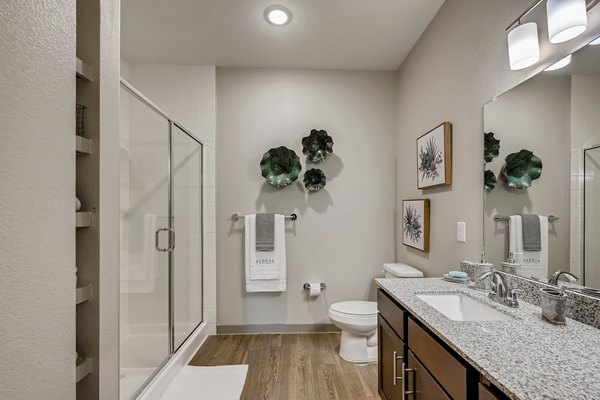 Bathroom with modern fixtures at Alders Magnolia Apartments, featuring sleek countertop and spacious layout