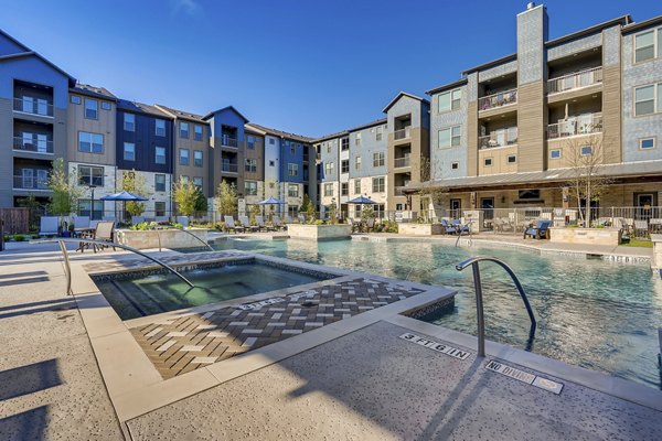 Outdoor pool with lounge area at Alders Magnolia Apartments
