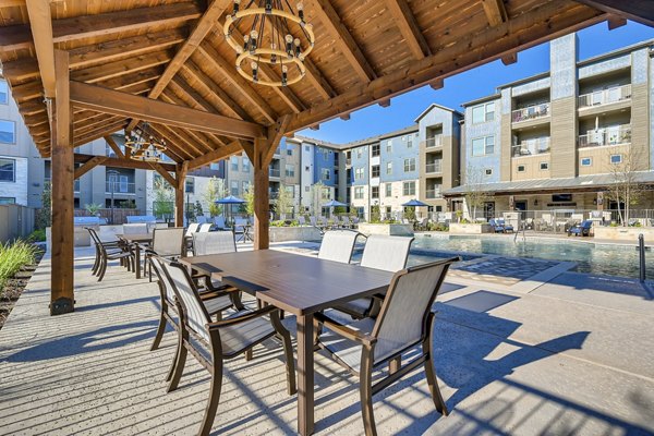 Charming patio with stylish outdoor seating at Alders Magnolia Apartments, offering luxury living in a serene setting