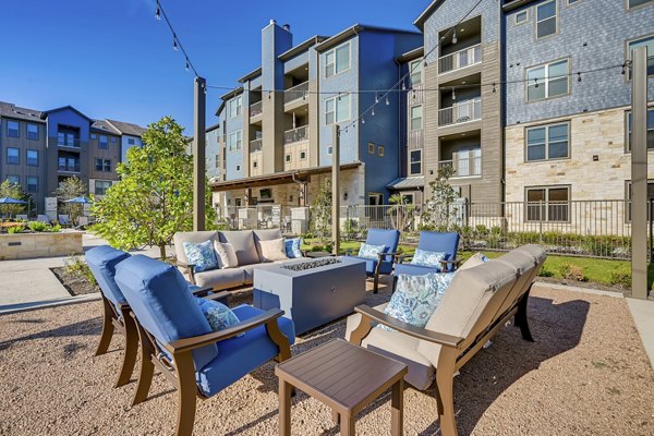 Cozy outdoor fire pit surrounded by seating at Alders Magnolia Apartments