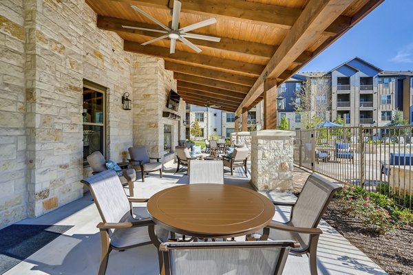 Patio with stylish seating and lush landscaping at Alders Magnolia Apartments