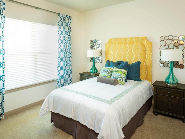 Bedroom with cozy decor and ample natural light at The Orchards at Market Plaza Apartments