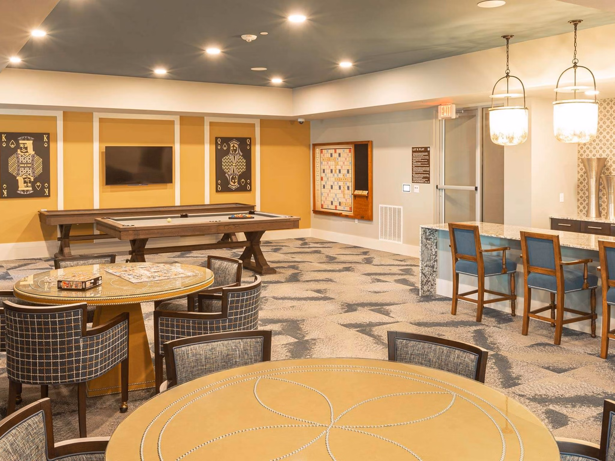 Game room with modern entertainment options at The Orchards at Market Plaza Apartments, featuring a pool table and arcade games