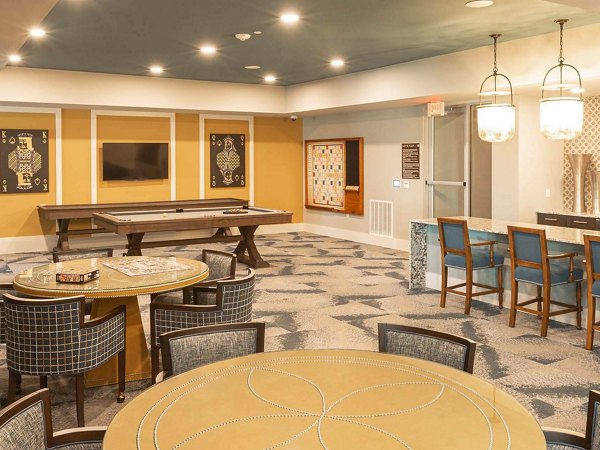 Game room with modern entertainment options at The Orchards at Market Plaza Apartments, featuring a pool table and arcade games