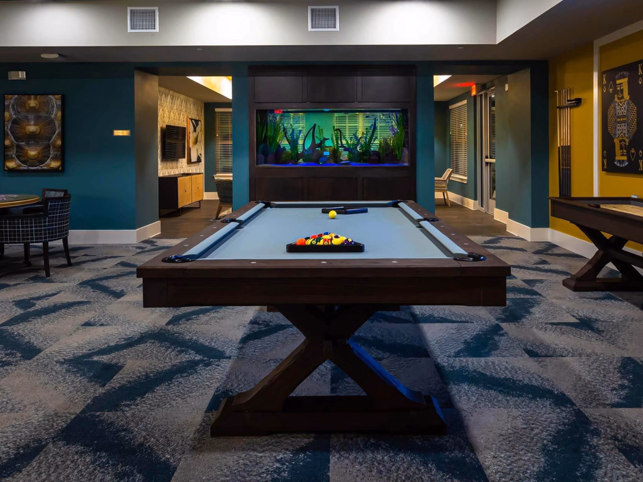 Vibrant game room with pool tables and lounge seating at The Orchards at Market Plaza Apartments