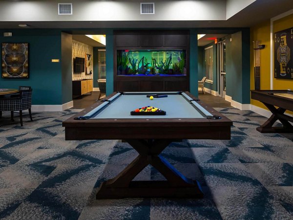 Vibrant game room with pool tables and lounge seating at The Orchards at Market Plaza Apartments