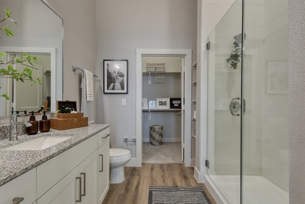 Modern bathroom with sleek fixtures at Encore Grayson Apartments, featuring marble countertops and spacious shower