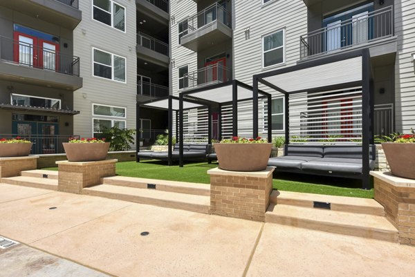Courtyard with modern seating and lush landscaping at Encore Grayson Apartments