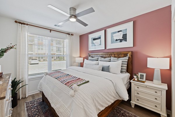 Bedroom with modern decor and large window at Silos Harvest Green Apartments