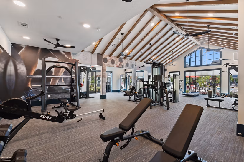 Well-equipped fitness center at Silos Harvest Green Apartments, featuring modern machines and weights ideal for active residents