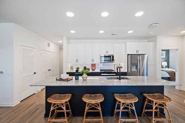 Modern kitchen featuring stainless steel appliances and granite countertops at Silos Harvest Green Apartments