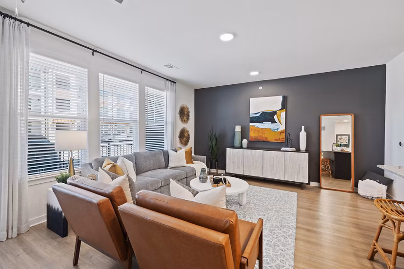 Modern living room with cozy seating and natural light at Silos Harvest Green Apartments