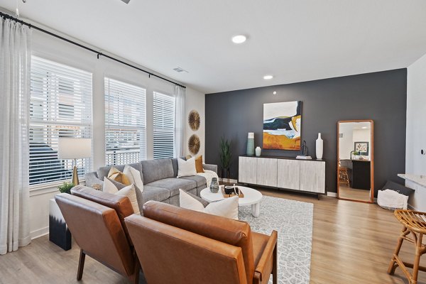 Modern living room with cozy seating and natural light at Silos Harvest Green Apartments