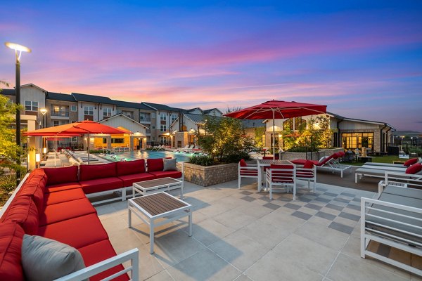 Outdoor patio area with modern seating and lush greenery at Silos Harvest Green Apartments, ideal for relaxation and socializing