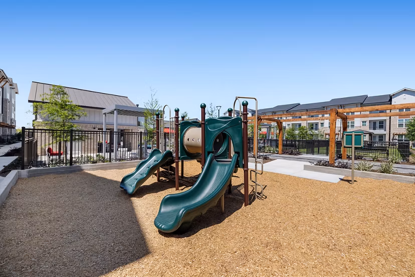 Children's playground with slides and swings at Silos Harvest Green Apartments
