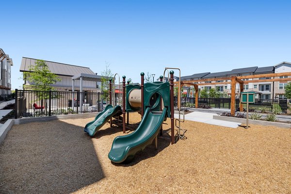 Children's playground with slides and swings at Silos Harvest Green Apartments