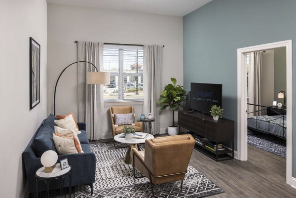 Spacious living room with sleek furniture and natural light in Prose McCullough Station Apartments