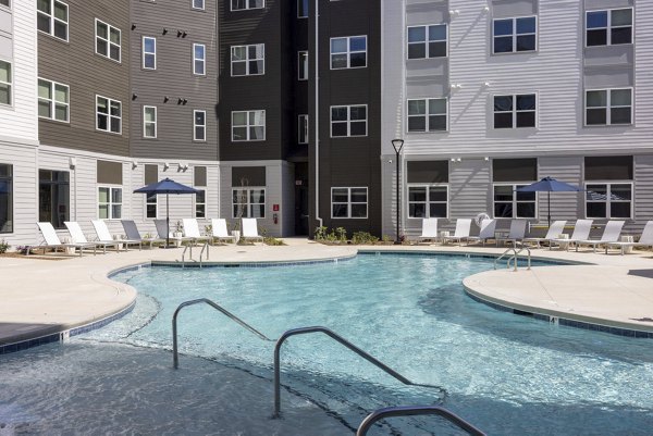 Resort-style pool with lounge chairs at Prose McCullough Station Apartments, ideal for relaxation in a luxury setting