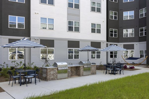 Outdoor grill area with modern seating at Prose McCullough Station Apartments, ideal for social gatherings and barbecue enthusiasts